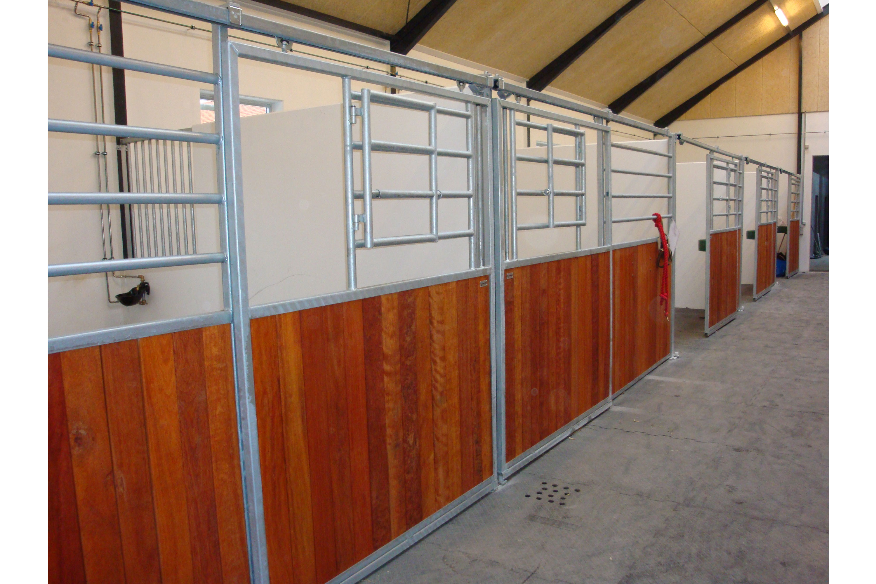 Grand Prix hesteboks med vannrette spiler og sidehengslet gitter i skyvedør så hestene kan stikke hode ut.