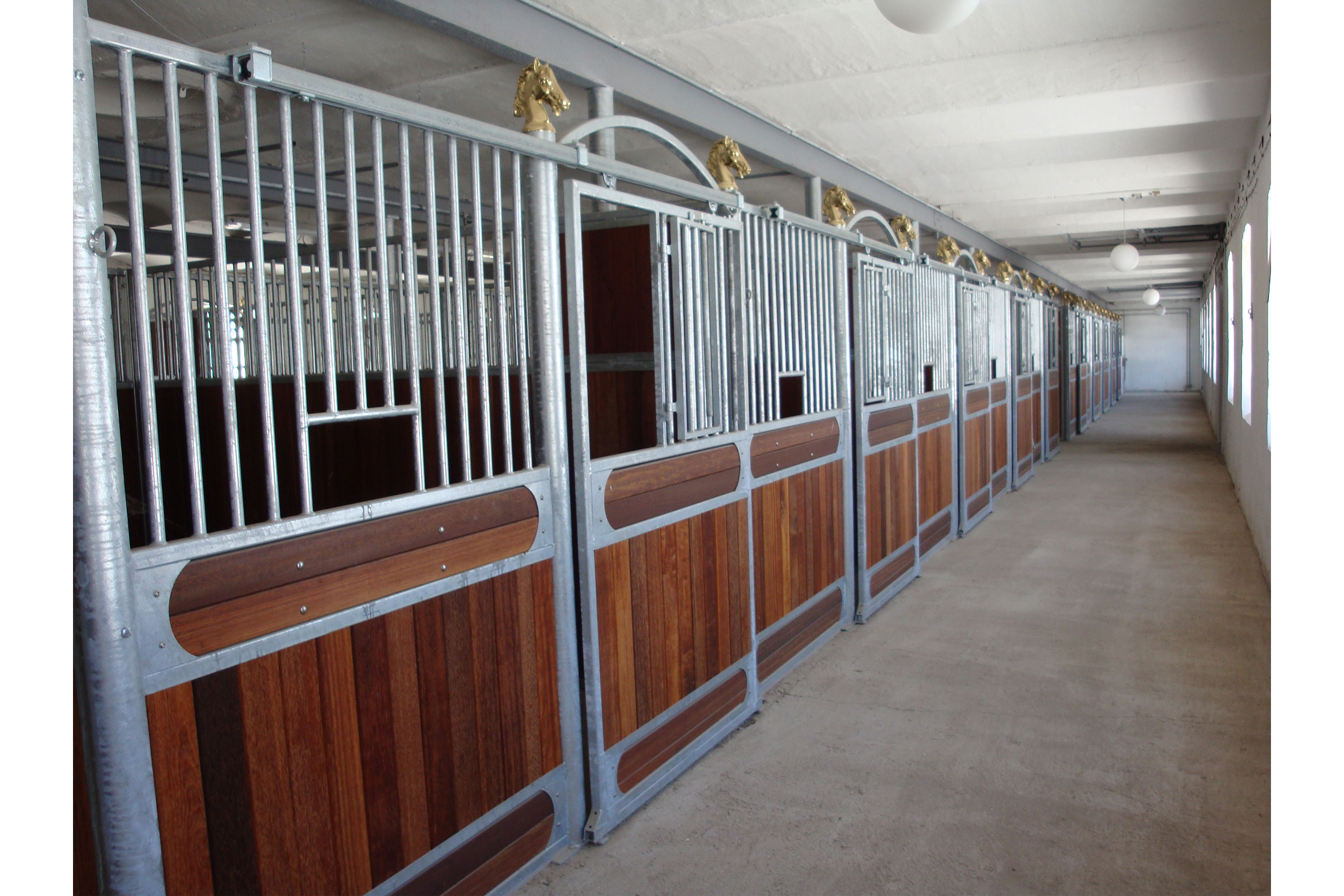 Avantgarde hestebokser med luke i gitter som kan åpnes og hestehoder som pynt.